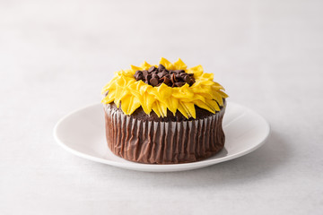 Beautiful sunflower decorated chocolate cupcake on white background
