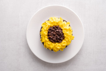 Beautiful sunflower decorated chocolate cupcake on white background