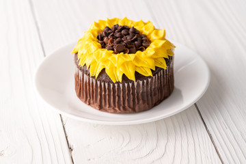 Beautiful sunflower decorated chocolate cupcake on white wood background