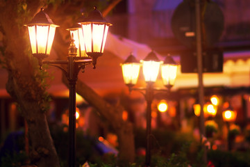 Obraz na płótnie Canvas Night street lanterns in retro style. Beautiful illumination of Italy old town at night. Selective focus
