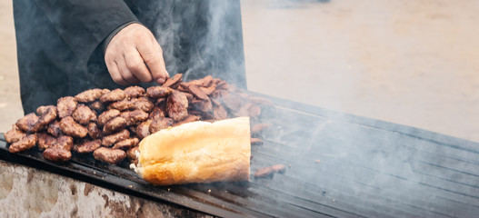 Man picking Camel meat from barbecue during Camel wrestling festival.