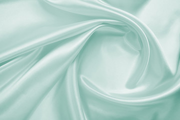 Delicate satin draped fabric of blue color texture for festive backgrounds