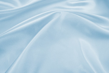 Delicate satin draped fabric of blue color texture for festive backgrounds