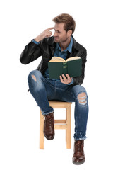 seated man with book imitating crazy gesture