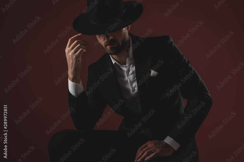 Canvas Prints mysterious young man wearing tuxedo and arranging hat