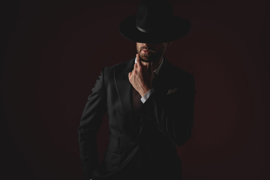 mysterious young man wearing tuxedo and black hat