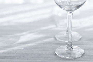 Several empty wine glasses in white grey shades on the white tablecloth