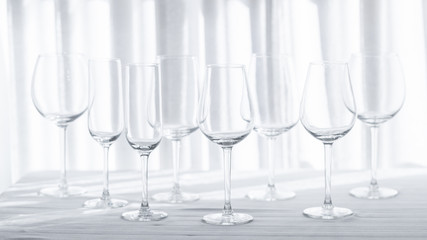 Several glasses for different kind of wine on the white tablecloth.