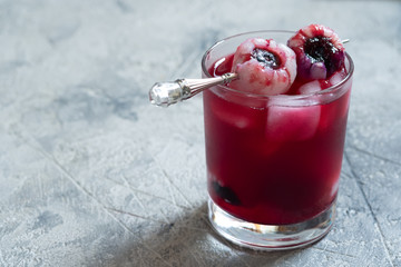 Red halloween cocktail with lychee and blueberry eye