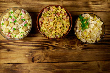 Set of festive mayonnaise salads on wooden table. Top view, copy space