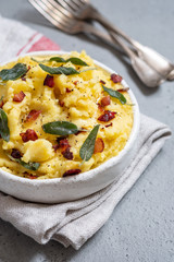 Mashed potatoes with crispy bacon and sage in a bowl
