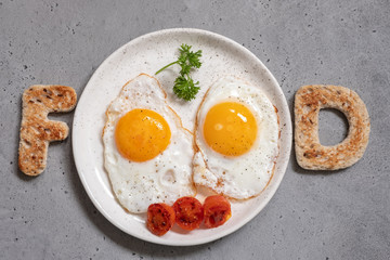 Word food written with toast letters fried eggs