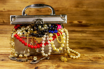 Jewelry box full of jewelry and accessories on wooden background