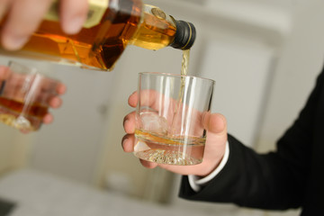 close up of a hand holding a glass of whiskey