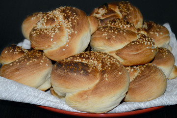buns with sesame seeds on a napkin and a red plate