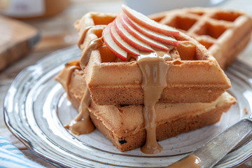 Waffles with peanut butter and red apple