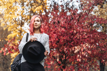Pretty girl with red hair and hat walking in the park, autumn time.