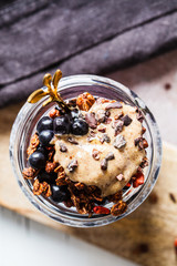 Chia pudding with berries, granola and peanut butter in jar, top view. Healthy vegan breakfast.