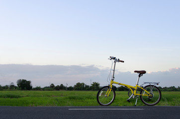 Obraz premium Feel strong, active and fresh when ride yellow bicycle to survey rice field with good air and no polution.