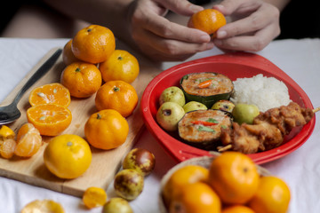 Traditional Thai meal of Haw Moak or steamed curried fish with white steamed rice and clementine oranges