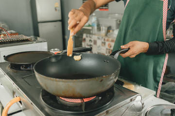 Chef is putting butter into the hot pan.