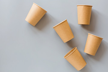 eco natural paper coffee cups flat lay on gray background. sustainable lifestyle concept. zero waste, plastic free items. stop plastic pollution. Top view, overhead, mockup, template