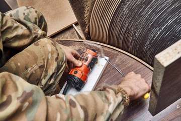 Joinery. Faceless carpenter producing wooden coffee table in workshop