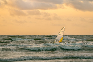 Windsurfing in a storm at sunset. Short Baltic wave. Beautiful shot.