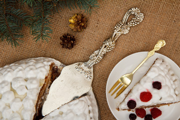 Sliced biscuit cake decorated with whipped cream and raspberries