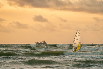 Windsurfing in a storm at sunset. Short Baltic wave. Beautiful shot.