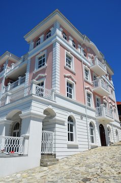 Nesabar, Bulgaria, 06/13/2017.  White and rose building on street of  Nesabar near black sea, blue  sky
