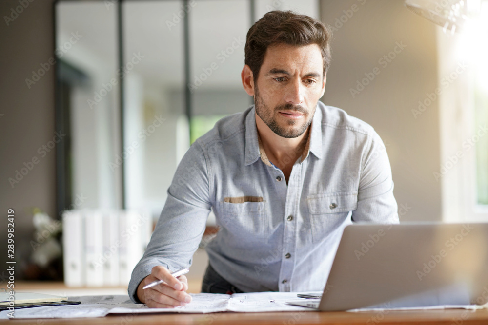 Wall mural Modern man working in office