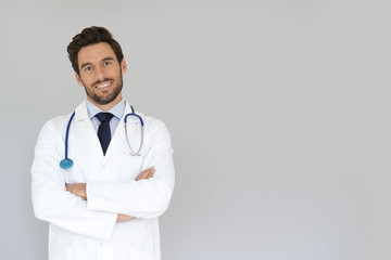 Smiling doctor standing on grey background