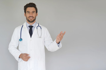 Smiling doctor standing on grey background