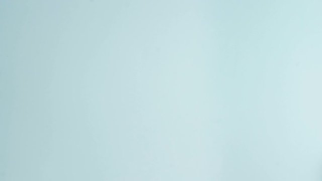 Macaroons or macaron on pastel blue surface with coffee in red cup.