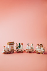 holiday concept.  Christmas and New Year.  postcard.  small toy miniature train with Santa, snowman, Christmas tree, on a pink background in isolation