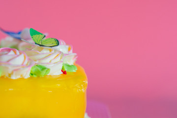 Butter cream of Pink Roses decorated on orange pond cake on pink background with copy space served in Birthday Party and wedding. Delicious sweet bakery for someone you love.