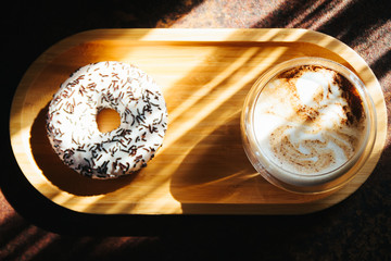 Cappuccino in a transparent glass in the morning sun. Morning in cafeteria. Sunlight. Close up....
