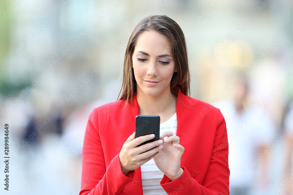 Sticker Front view of serious woman in red using phone