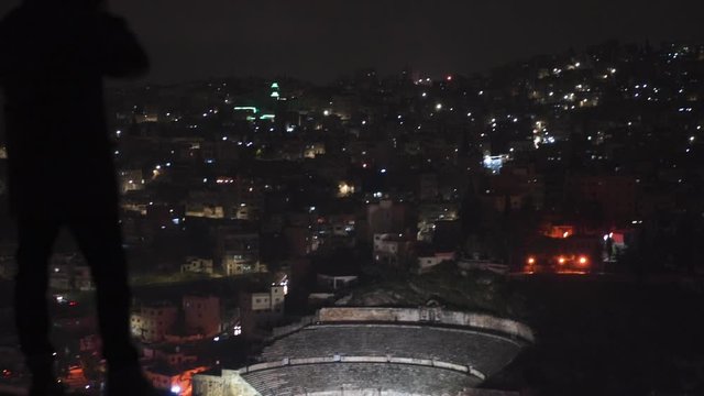 photographer taking a picture of amman's citadel landscape during the night