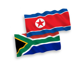 National vector fabric wave flags of North Korea and Republic of South Africa isolated on white background. 1 to 2 proportion.