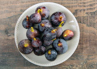 organic figs in a white plate on  wooden background