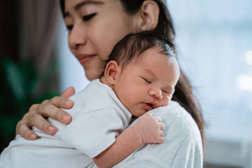 asian mother embrace carrying newborn little daughter with love