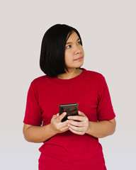 Happy woman is thinking with smartphone on white background