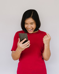 Surprised happy woman looking at the smartphone on white background