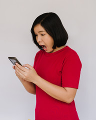 Surprised happy woman looking at the smartphone on white background