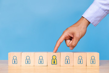 Businessman choose human icon on blue background. Concept of human resources management and recruitment business