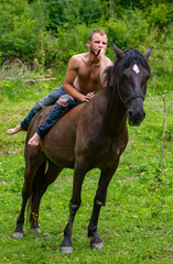 man with a naked torso riding horse