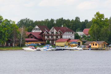 Fototapeta premium building on the banks of the river and the pier for boats. Summer and rest. Russia, Moscow region, August 2108.