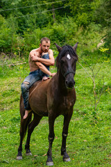 man with a naked torso riding horse